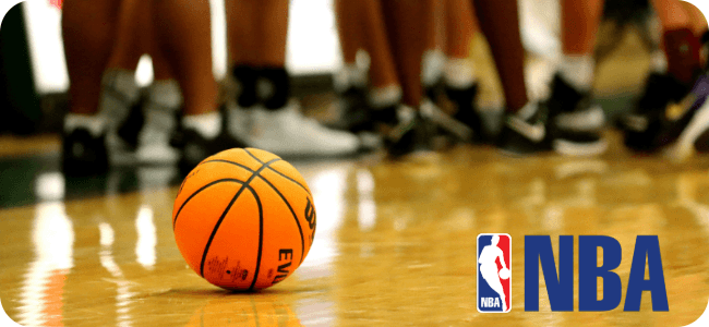 A conductor conducting the Auckland Philharmonia Orchestra in a large concert hall.